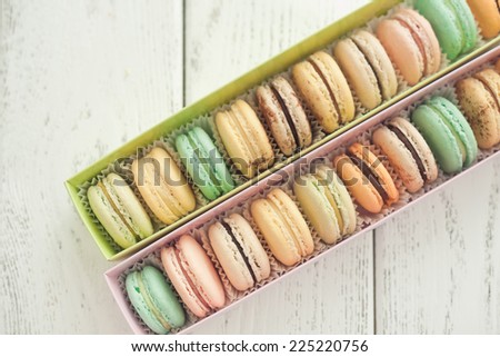 box with macaroons on wooden background