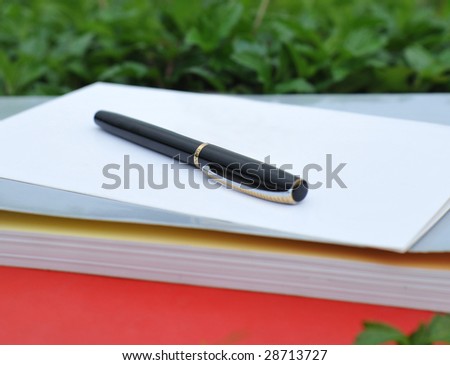 In outdoors lawn pen, card and book