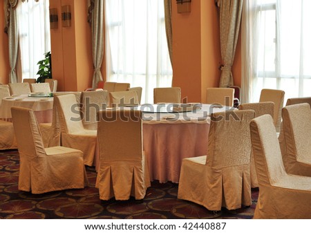 Interior of chinese restaurant with round tables and  chairs.
