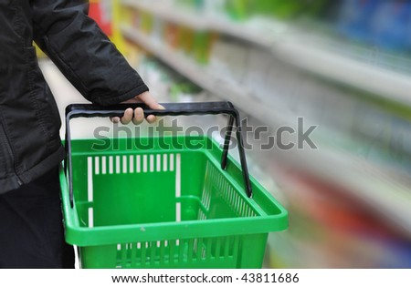 hand is taking the shopping basket in the market