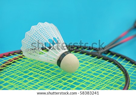 Shuttlecock and badminton racket on blue background