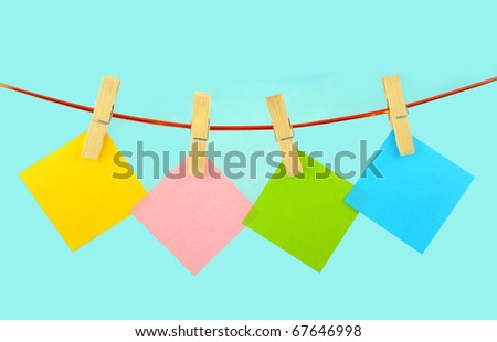 scratch paper with wooden clamp on Blue background