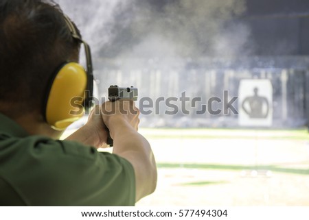 law enforcement aiming and shooting gun in academy shooting range surround with smoke and copy space