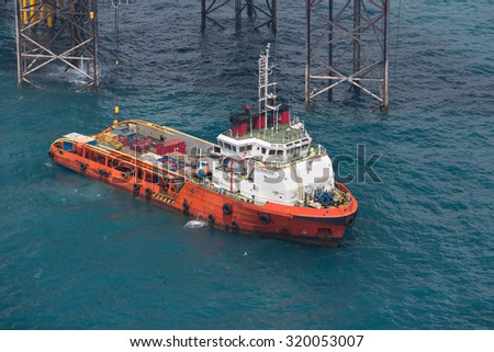 Supply vessel during operation along side with a drilling rig. Coast of Thailand