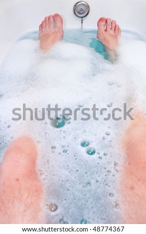a person in a bathtub. visible are only the feet