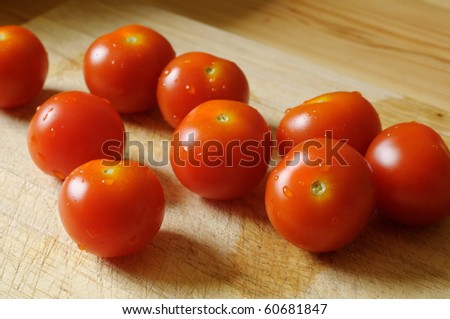 a few of tomatoes on a wooden plate side by side