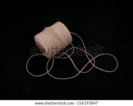 Ball of string or twine on a plain black background.