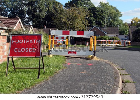 Road work warning signs and barriers in a street in England.