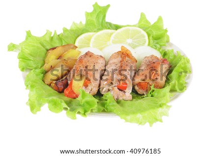 Meat loaf on  leaf of salad with a lemon and an onions