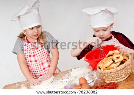 two children in chef\'s hats on grey background