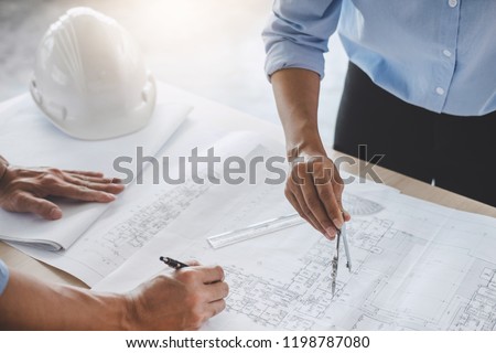 Construction concept of Engineer or architect meeting for project working with partner and engineering tools on model building and blueprint in working site.