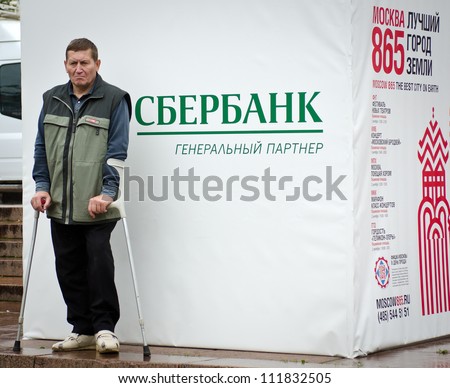 MOSCOW - SEPTEMBER 2: Disabled man near poster with logo \