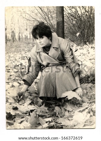VORONEZH - CIRCA 1989: Girl collects maple leaves in autumn park, Voronezh, Russia, USSR, 1989