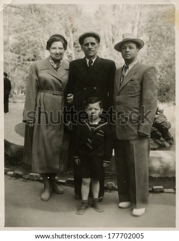 KIEV, UKRAINE, USSR - CIRCA 1950s: An antique photo shows outdoor portrait of a Soviet family - father, mother, son and grandfather