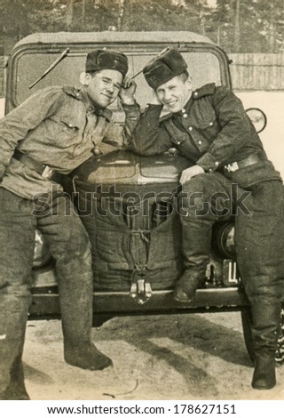 MOSCOW, USSR - CIRCA 1960s : An antique photo shows two Red Army near the military vehicle UAZ. 