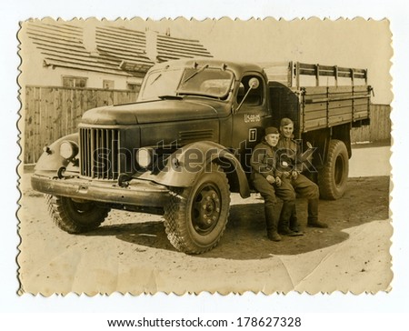 MOSCOW, USSR - CIRCA 1960s : An antique photo shows two Red Army soldiers near a military truck ZIL. \