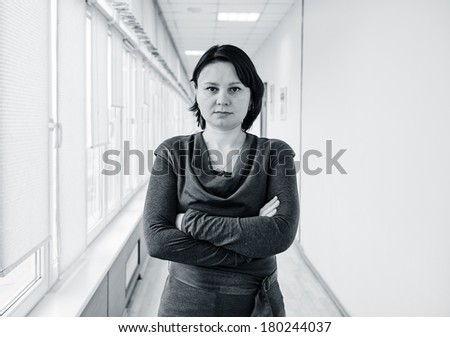 Black and white portrait of a mature woman (office worker), standing in the gallery.
