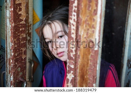 Little girl standing near an open window