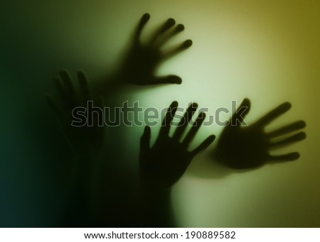 hands silhouette behind glass