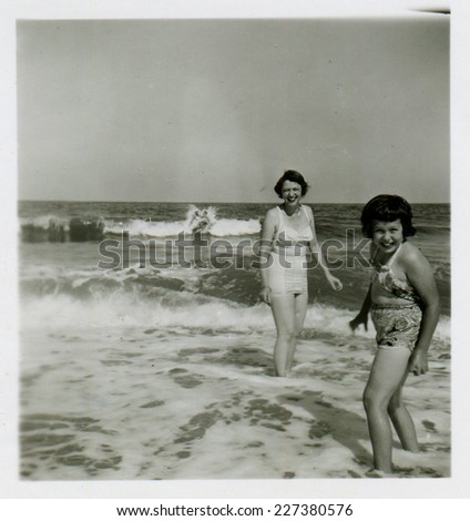CANADA - CIRCA 1950s: Vintage photo shows mother and her daughter swimming in the sea.