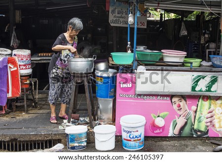 BANGKOK, THAILAND - DECEMBER 25, 2014: Street Photography of Street market in China town. Elderly woman cooking soup in a large vat.