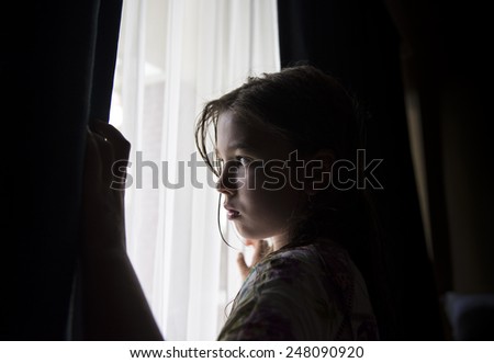 Little girl looking out the window