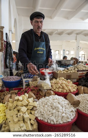 BUKHARA, UZBEKISTAN - MARCH 14, 2015: City grocery market. Man sells traditional Uzbek sweets.