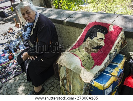 TBILISI, GEORGIA - MAY 01, 2015: An elderly woman sells portrait of Joseph Stalin on Dry Bridge market in Tbilisi, Georgia. Dry bridge today is most famous flea market in Georgia.