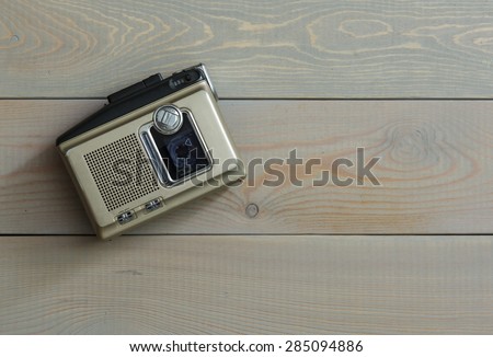 Magnetic audio tape cassette recorder on a wooden background
