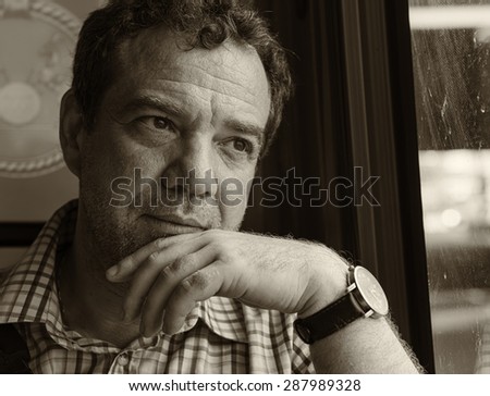 Mature man sitting at the window a public bus. Black and white portrait. 