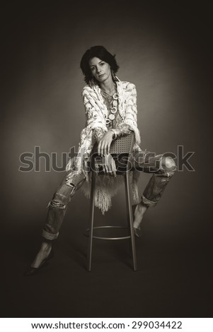 Studio portrait of young woman sitting on a chair. Black and white photo