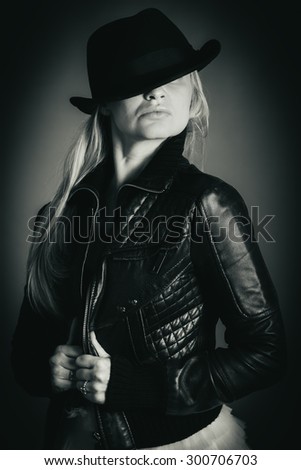 Black and white portrait of a girl in a hat and leather jacket