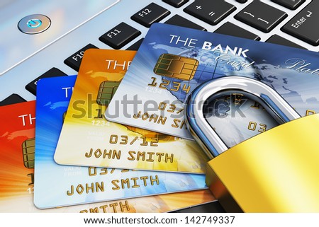 Creative mobile banking, commerce and security payment financial business concept: macro view of group of color credit cards and golden padlock on laptop computer PC notebook keyboard