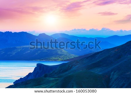 Scenic summer evening sunset in mountains landscape with sea coast