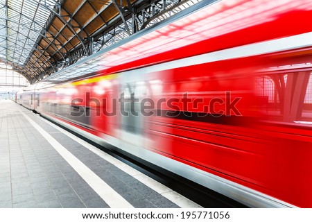 Creative abstract railroad travel and railway transportation industrial concept: modern red high speed electric passenger commuter train at station platform with motion blur effect