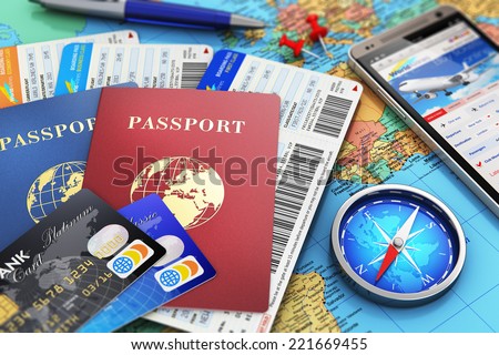 Business travel and tourism concept: air tickets or boarding pass, passports, smartphone with online airline tickets booking or reservation internet app, compass, credit cards and pen on world map