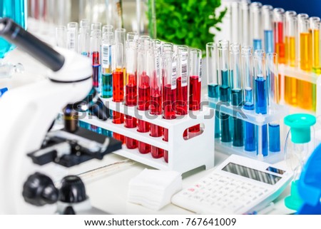 Creative abstract chemistry development, medicine, pharmacy, biology, biochemistry and research technology concept: table with scientific chemical laboratory equipment - microscope and test tubes