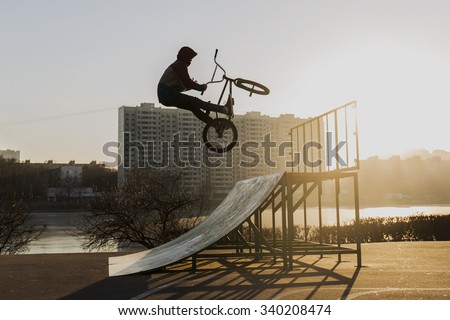 Extreme bike rider jumping in Moscow skate park at the sunset