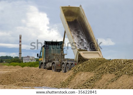 Truck or lorry unloading gravel or rock with lifted loading platform