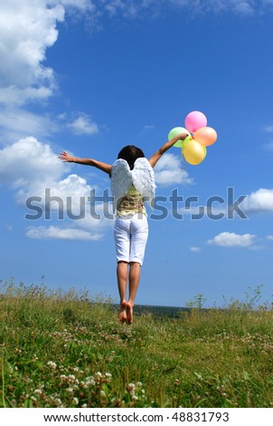 Happy young woman flying with colorful balloons