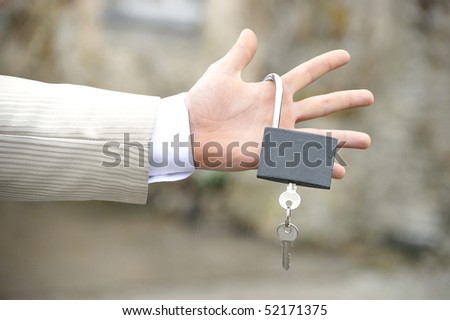 Man\'s hand holding lock with key