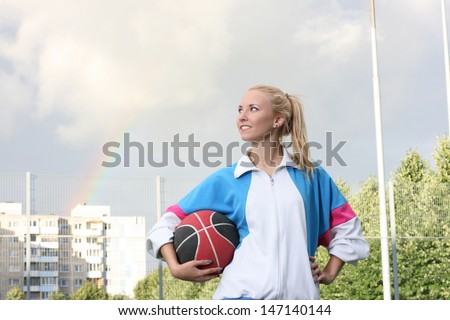 Young sporty girl holding basketball ball