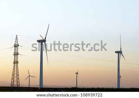windmills for renewable electric energy production and high voltage tower, La Muela, Zaragoza, Aragon, Spain