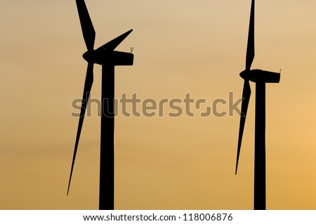 silhouette of two windmills for renewable electric energy production