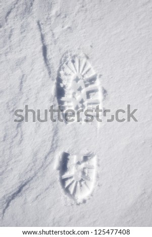 forefront of a boot print in the snow mountain