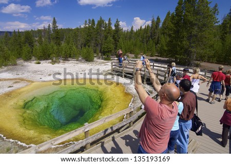 YELLOWSTONE, USA - AUGUST 19: colors on August 19, 2007 in Yellowstone: Several tourists come to photograph the Morning Glory. The Morning Glory is one of the major attractions of the park.