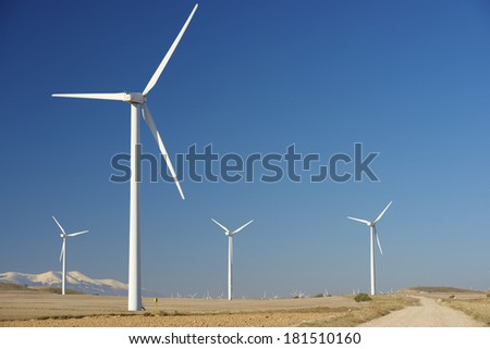 Windmills for renewable electric energy production, at background is Moncayo Peak, Pozuelo de Aragon, Zaragoza, Aragon, Spain