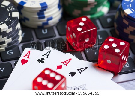 Casino chips, cards and dices stacking on a laptop