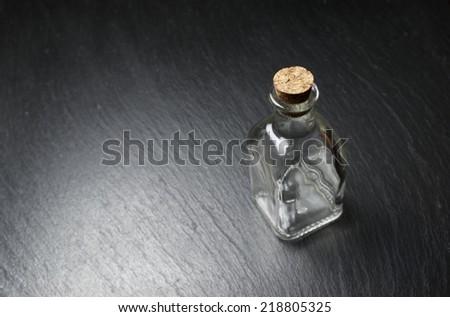 small empty bottle on a black slate