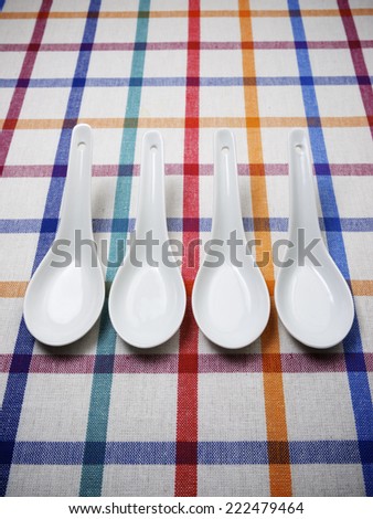 Small white spoons on a white tablecloth